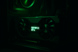 Nvidia GeForce Drivers - RTX grafikkort med grøn LED-belysning monteret i en gaming-PC, set i mørkt kabinet med fokus på blæsere og logo.
